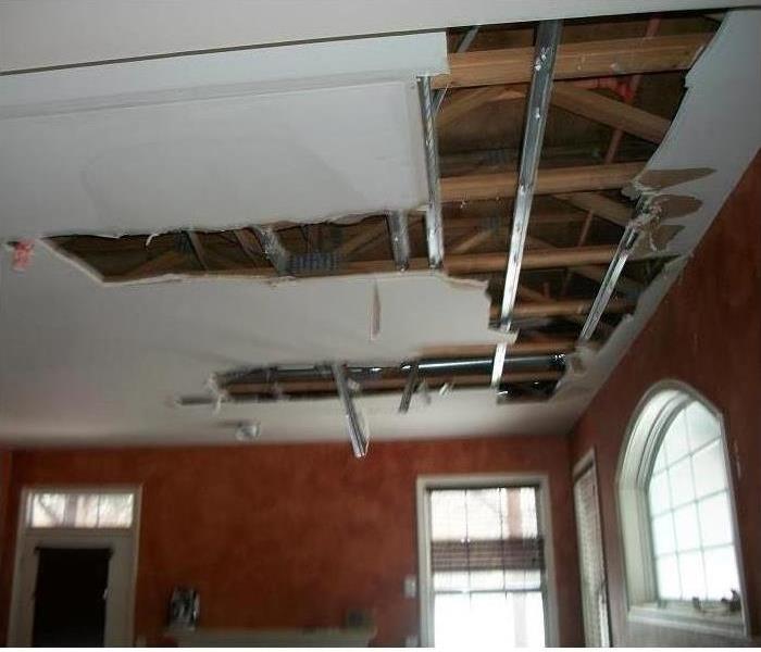 exposed view of attic crawlspace with damaged ceiling panels