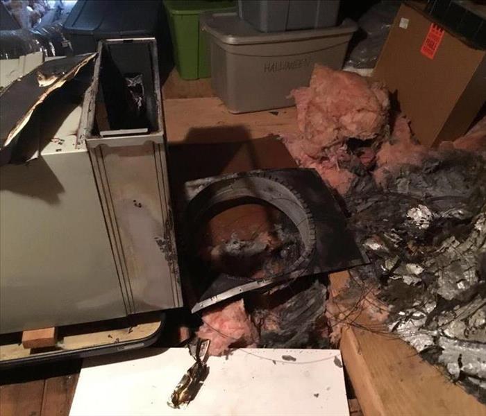 garage with burnt debris and a toppled air handler