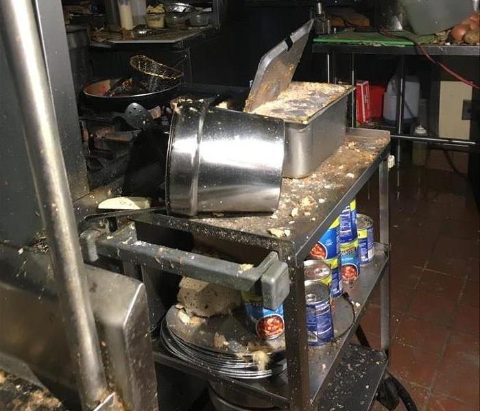 Restaurant kitchen with soot and debris on the tables and stoves
