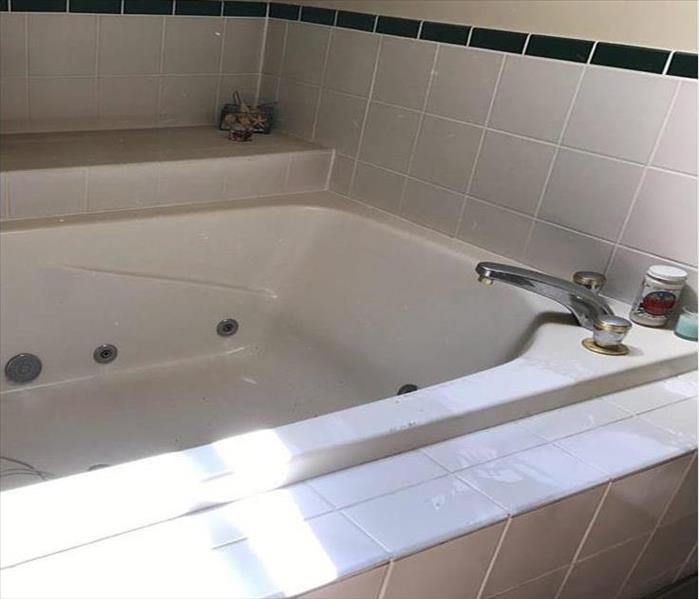 sooty deposits on a spa tub and tiles in a bathroom