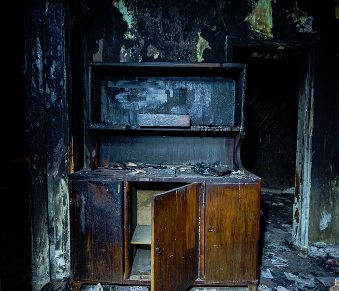 fire damaged room with burned cabinet