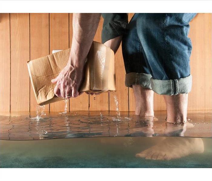 man with bare feet lifting a box out of water